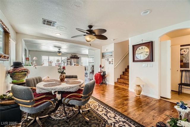 4832 Englewood Ave, Las Vegas, NV 89139 - dining room with a ceiling fan, wood finished floors, stairway, arched walkways, and baseboards