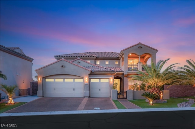 2240 Boutique Ave, Henderson, NV 89044 - mediterranean / spanish house featuring a balcony, asphalt driveway, a tiled roof, stucco siding, and a garage