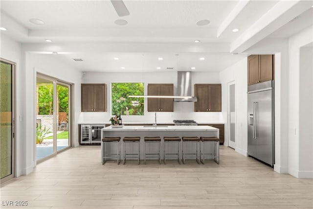 2240 Boutique Ave, Henderson, NV 89044 - kitchen featuring stainless steel built in refrigerator, wall chimney exhaust hood, wine cooler, a breakfast bar area, and recessed lighting