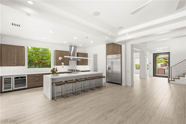 2240 Boutique Ave, Henderson, NV 89044 - kitchen featuring built in fridge, beverage cooler, wall chimney range hood, healthy amount of natural light, and recessed lighting