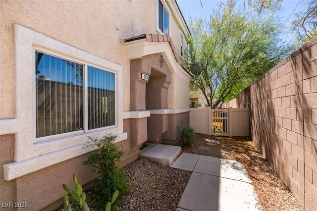 5509 Ante Up Ct Unit 102, Las Vegas, NV 89122 - view of property exterior with stucco siding and a gate