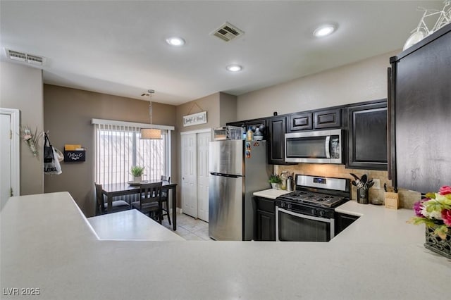 5509 Ante Up Ct Unit 102, Las Vegas, NV 89122 - kitchen with stainless steel appliances, light countertops, backsplash, recessed lighting, and hanging light fixtures