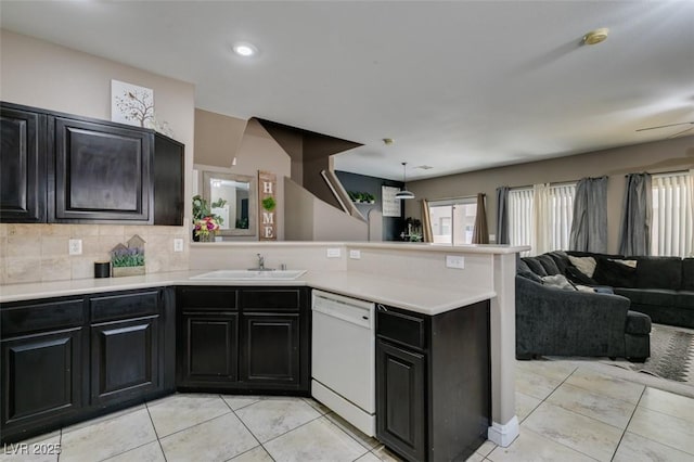5509 Ante Up Ct Unit 102, Las Vegas, NV 89122 - kitchen featuring white dishwasher, a peninsula, open floor plan, dark cabinets, and a sink