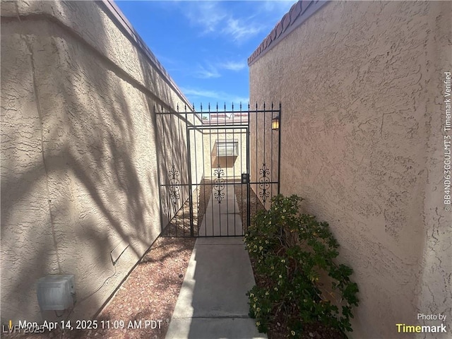 view of side of property with a gate and stucco siding