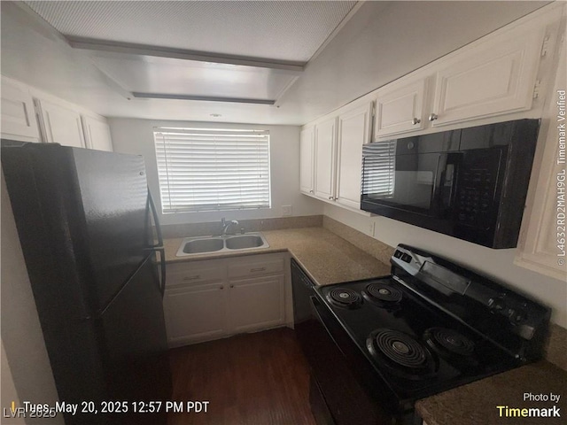 kitchen with black appliances, a sink, white cabinetry, dark wood-type flooring, and light countertops