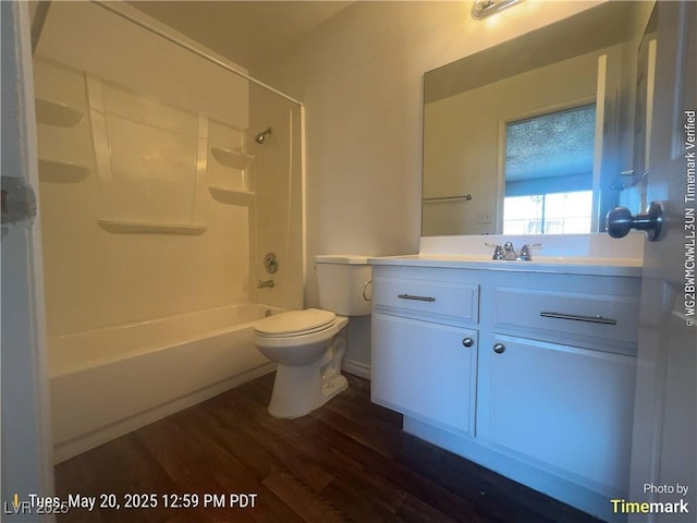 full bath featuring wood finished floors, toilet, vanity, and shower / tub combination