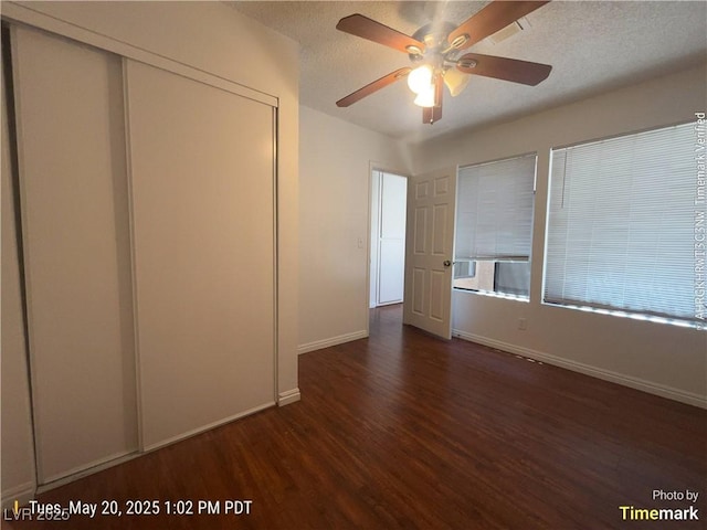 unfurnished bedroom featuring wood finished floors, a closet, baseboards, a textured ceiling, and a ceiling fan