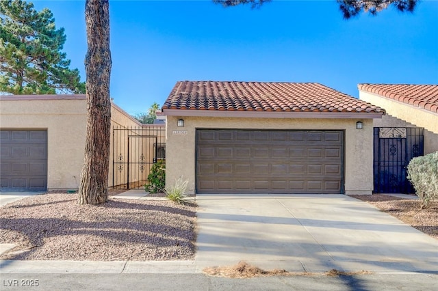 1850 Camino Verde Ln, Las Vegas, NV 89119 - mediterranean / spanish-style house featuring stucco siding, a tile roof, driveway, and a gate