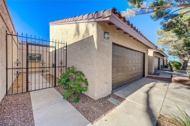 1850 Camino Verde Ln, Las Vegas, NV 89119 - view of property exterior with stucco siding, a gate, a tile roof, and concrete driveway
