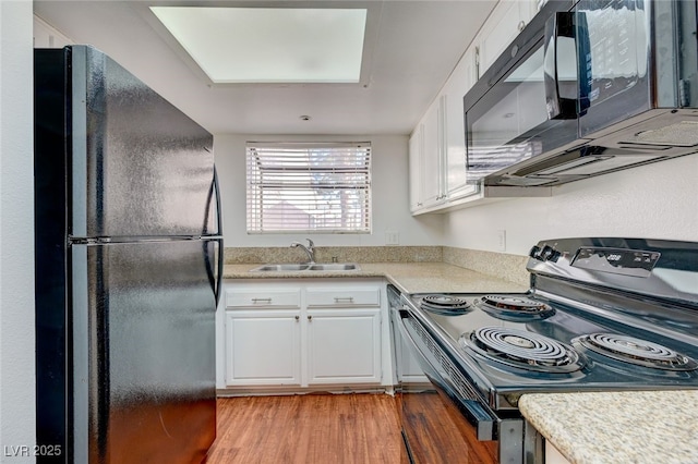 1850 Camino Verde Ln, Las Vegas, NV 89119 - kitchen with black appliances, white cabinets, wood finished floors, and light countertops