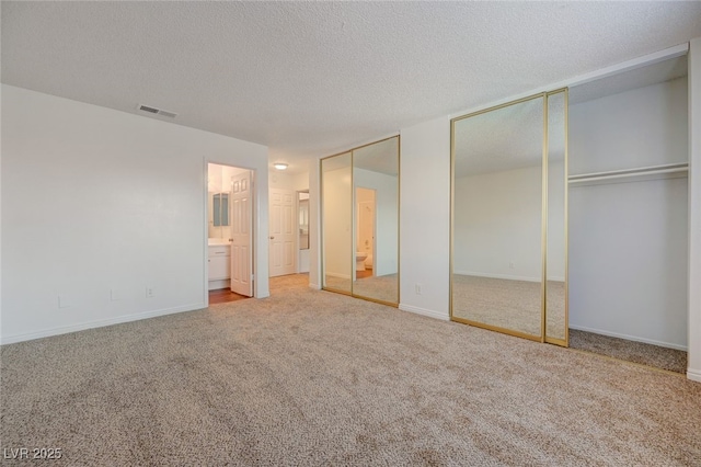 1850 Camino Verde Ln, Las Vegas, NV 89119 - unfurnished bedroom with multiple closets, carpet, connected bathroom, and a textured ceiling