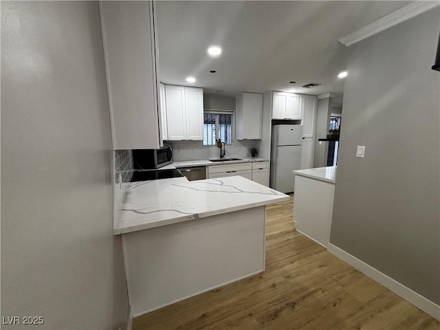 150 Greenbriar Townhouse Way, Las Vegas, NV 89121 - kitchen featuring appliances with stainless steel finishes, a sink, light stone countertops, light wood-style flooring, and white cabinets