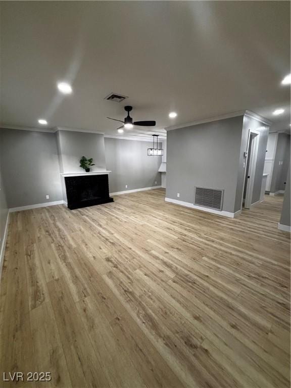 150 Greenbriar Townhouse Way, Las Vegas, NV 89121 - unfurnished living room with crown molding, a ceiling fan, a fireplace, baseboards, and light wood-style floors