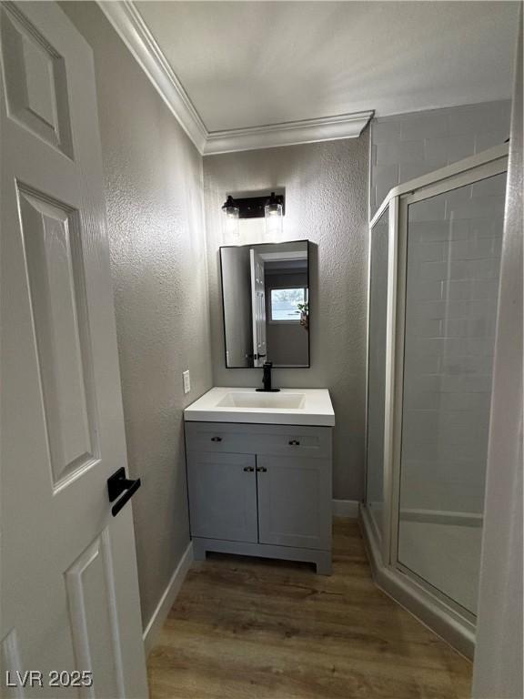 150 Greenbriar Townhouse Way, Las Vegas, NV 89121 - bathroom with ornamental molding, a stall shower, a textured wall, wood finished floors, and vanity