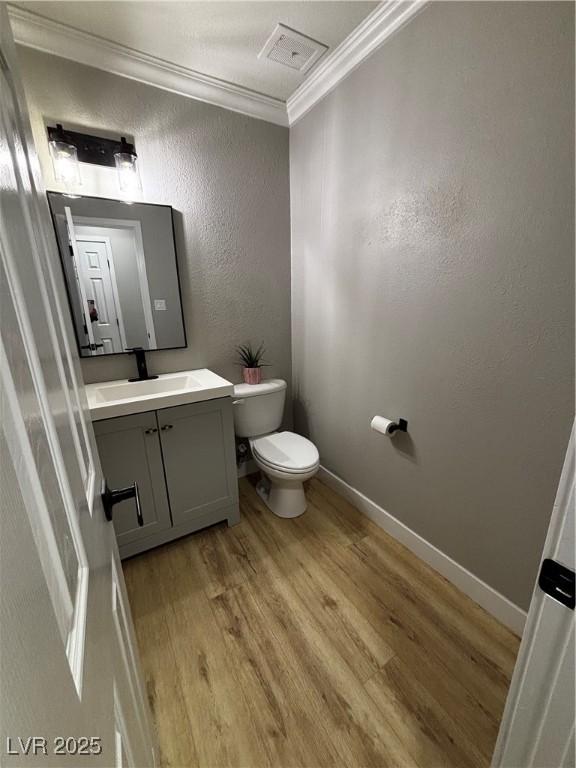 150 Greenbriar Townhouse Way, Las Vegas, NV 89121 - bathroom featuring crown molding, wood finished floors, a textured wall, toilet, and vanity