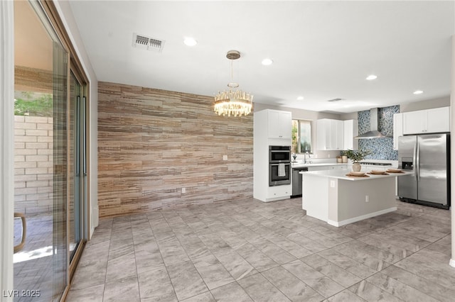 11847 Corenzio Ave, Las Vegas, NV 89138 - kitchen featuring stainless steel appliances, a center island, wall chimney exhaust hood, light countertops, and recessed lighting