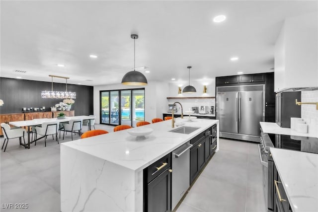 3189 Montecito Dr, Las Vegas, NV 89120 - kitchen featuring high quality appliances, a sink, dark cabinets, pendant lighting, and recessed lighting