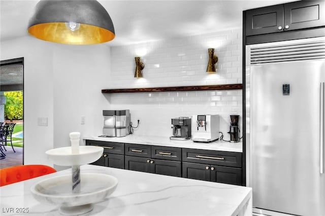 3189 Montecito Dr, Las Vegas, NV 89120 - kitchen featuring stainless steel built in fridge, backsplash, open shelves, light stone countertops, and dark cabinetry