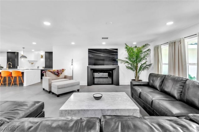 3189 Montecito Dr, Las Vegas, NV 89120 - living room with recessed lighting, concrete floors, and a glass covered fireplace