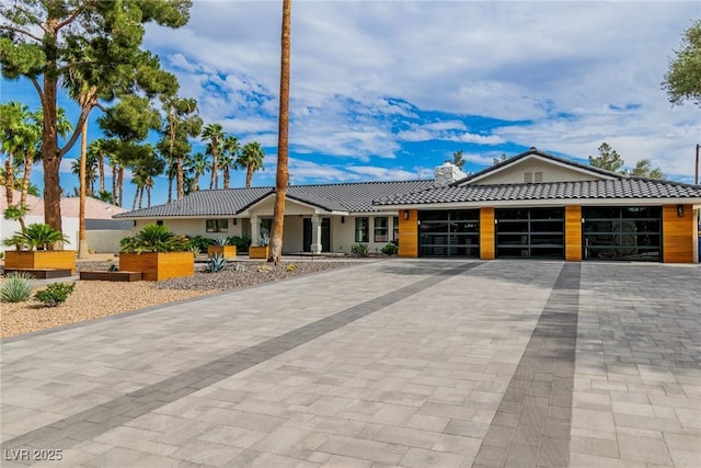 3189 Montecito Dr, Las Vegas, NV 89120 - view of front of property with a tiled roof, a garage, decorative driveway, and stucco siding