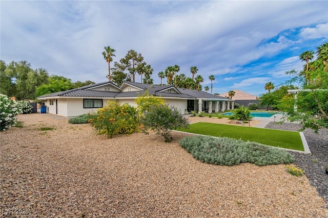 3189 Montecito Dr, Las Vegas, NV 89120 - rear view of house featuring stucco siding, a tile roof, an outdoor pool, and a lawn