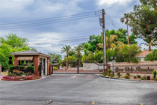 3189 Montecito Dr, Las Vegas, NV 89120 - view of asphalt street featuring curbs, a gate, a gated entry, and street lighting