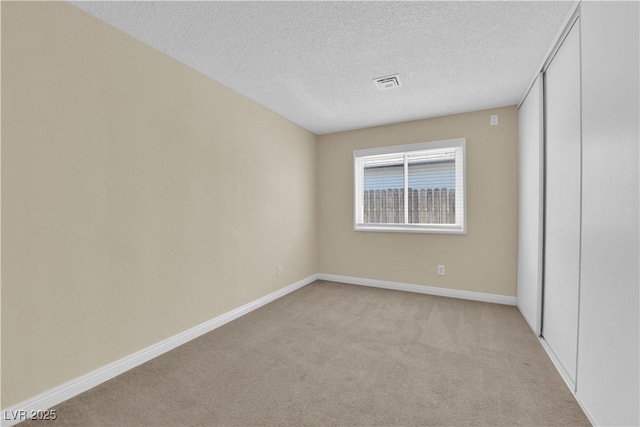 542 Grimsby Ave, Henderson, NV 89014 - unfurnished bedroom featuring light colored carpet, a textured ceiling, baseboards, and a closet