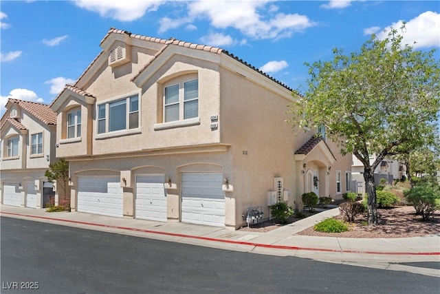 2596 Lazy Saddle Dr, Henderson, NV 89002 - townhome / multi-family property with stucco siding, a garage, and a tile roof