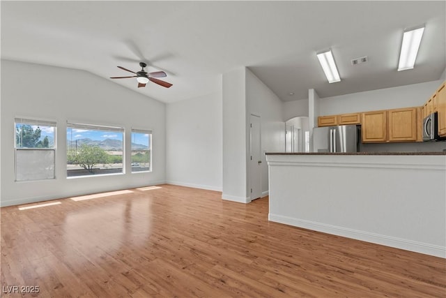 2596 Lazy Saddle Dr, Henderson, NV 89002 - unfurnished living room featuring lofted ceiling, arched walkways, a ceiling fan, light wood-style flooring, and baseboards