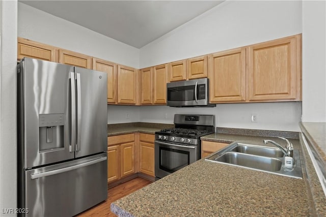 2596 Lazy Saddle Dr, Henderson, NV 89002 - kitchen with stainless steel appliances, a sink, dark countertops, wood finished floors, and vaulted ceiling