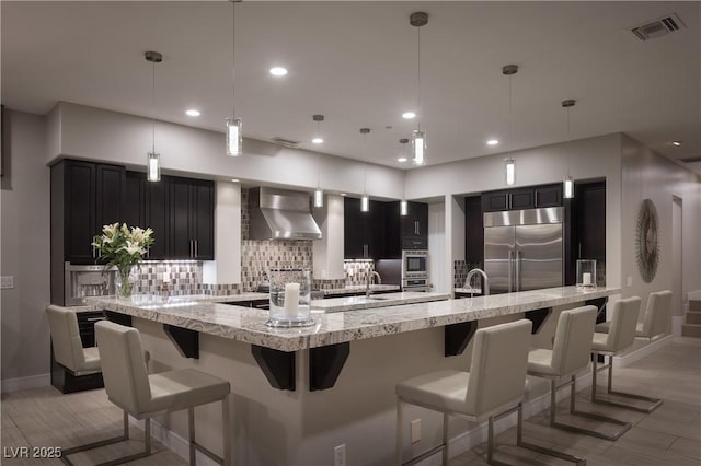 1683 Tangiers Dr, Henderson, NV 89012 - kitchen with wall chimney exhaust hood, stainless steel appliances, baseboards, decorative backsplash, and recessed lighting