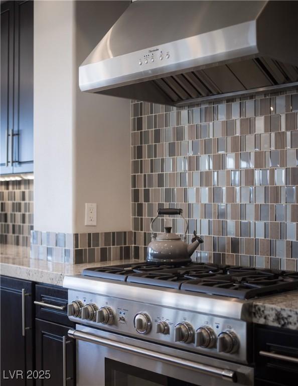 1683 Tangiers Dr, Henderson, NV 89012 - kitchen with high end stainless steel range oven, extractor fan, tasteful backsplash, light stone counters, and dark cabinetry