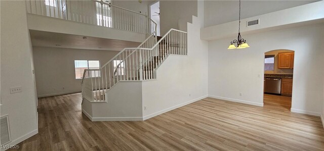 3750 Morning Canyon St, Las Vegas, NV 89147 - stairway with a high ceiling, wood finished floors, baseboards, a chandelier, and arched walkways