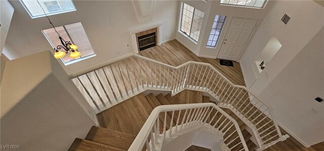 3750 Morning Canyon St, Las Vegas, NV 89147 - stairs with healthy amount of natural light, a chandelier, a towering ceiling, and wood finished floors