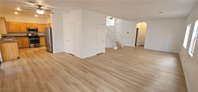 3750 Morning Canyon St, Las Vegas, NV 89147 - unfurnished living room featuring arched walkways, stairs, light wood-type flooring, a ceiling fan, and baseboards