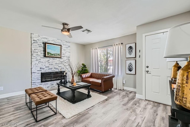445 Concord Way, Henderson, NV 89015 - living area featuring light wood-style floors, a ceiling fan, baseboards, and a stone fireplace
