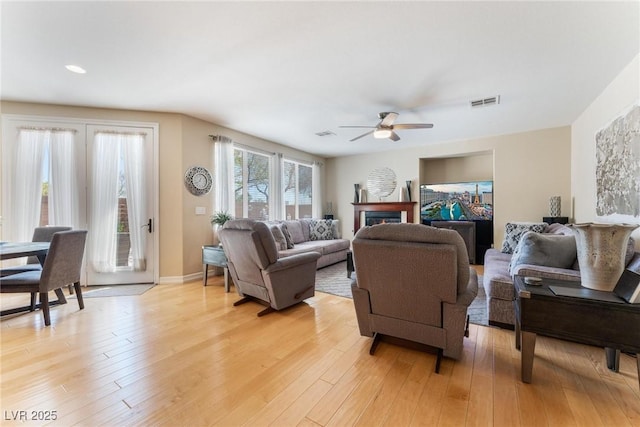 7567 Desertscape Ave, Las Vegas, NV 89178 - living room with ceiling fan, light wood-type flooring, a warm lit fireplace, baseboards, and recessed lighting