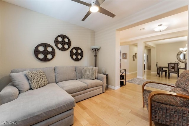 7567 Desertscape Ave, Las Vegas, NV 89178 - living room featuring a ceiling fan, light wood-style flooring, a chandelier, lofted ceiling, and baseboards