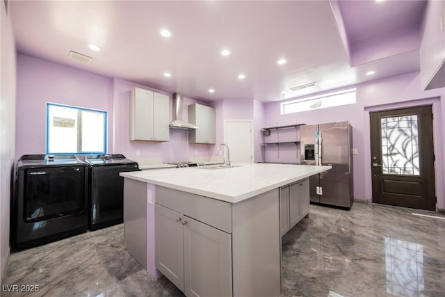 2807 Hermosa St, Las Vegas, NV 89169 - kitchen featuring wall chimney range hood, independent washer and dryer, marble tiled floors, plenty of natural light, and recessed lighting
