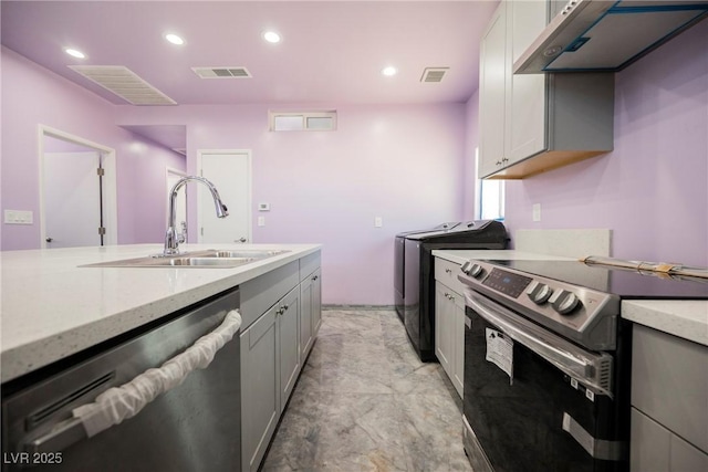 2807 Hermosa St, Las Vegas, NV 89169 - kitchen with stainless steel electric stove, dishwasher, a sink, under cabinet range hood, and separate washer and dryer