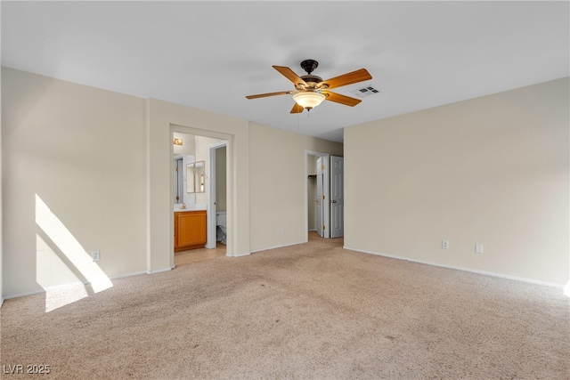 10791 Silver Lace Ln, Las Vegas, NV 89135 - unfurnished bedroom with light carpet, baseboards, ensuite bath, ceiling fan, and a walk in closet