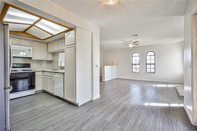 4083 Nook Way Unit D, Las Vegas, NV 89103 - kitchen featuring white appliances, light wood-style flooring, a ceiling fan, light countertops, and baseboards