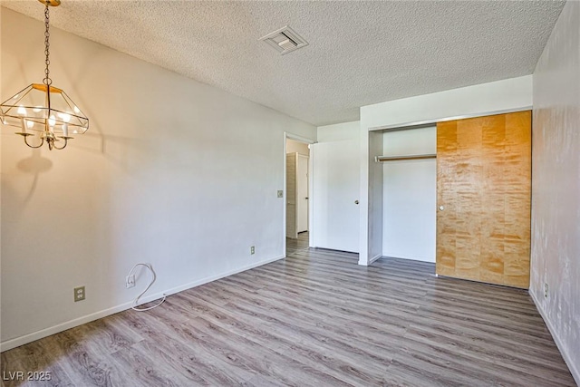 4083 Nook Way Unit D, Las Vegas, NV 89103 - unfurnished bedroom featuring wood finished floors, a chandelier, a textured ceiling, a closet, and baseboards