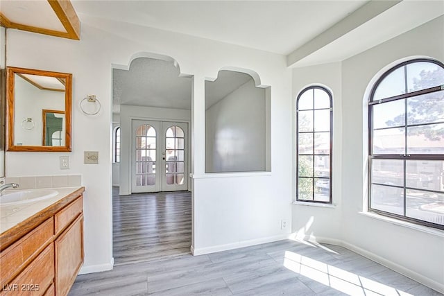 4083 Nook Way Unit D, Las Vegas, NV 89103 - unfurnished room with a sink, arched walkways, baseboards, and light wood-type flooring