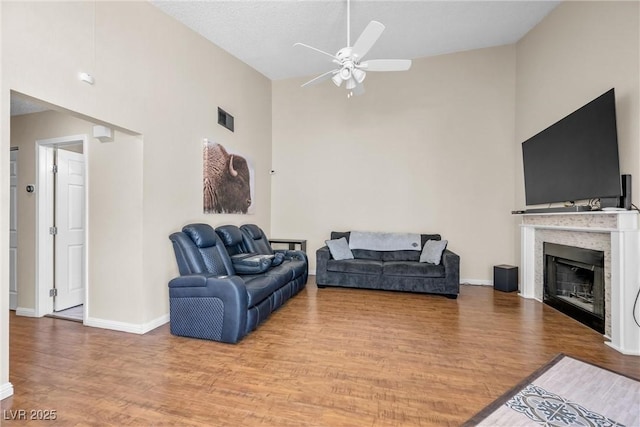 8932 Antioch Way, Las Vegas, NV 89117 - living room featuring high vaulted ceiling, a ceiling fan, wood finished floors, a fireplace, and baseboards