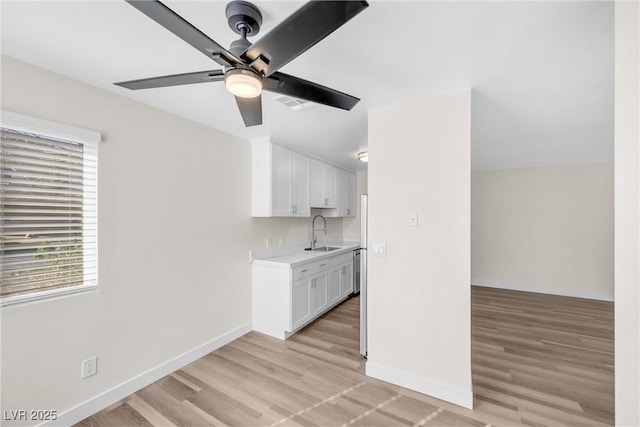 1832 N Decatur Blvd Unit 104, Las Vegas, NV 89108 - kitchen with a sink, ceiling fan, light countertops, white cabinets, and baseboards