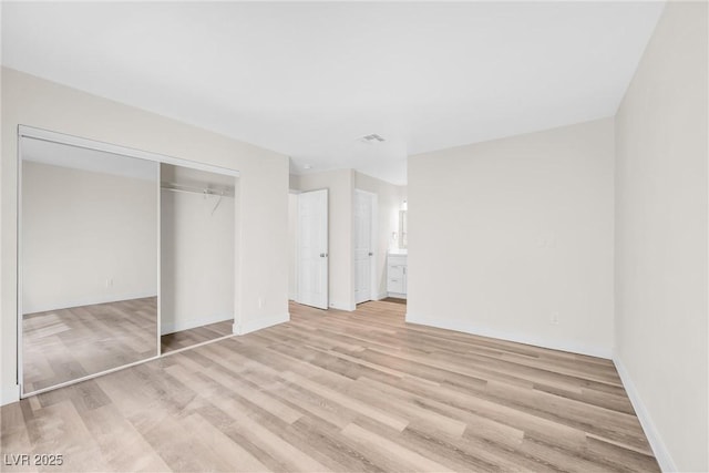 1832 N Decatur Blvd Unit 104, Las Vegas, NV 89108 - unfurnished bedroom with light wood-style flooring, baseboards, and a closet