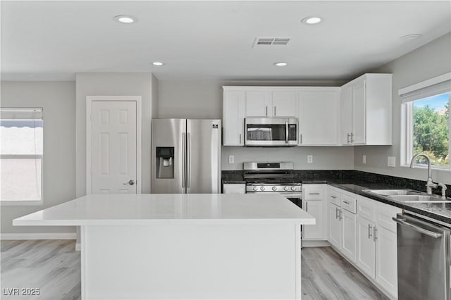 5116 Iron Crossing Ave, Las Vegas, NV 89131 - kitchen featuring appliances with stainless steel finishes, a sink, light wood-style floors, white cabinetry, and recessed lighting