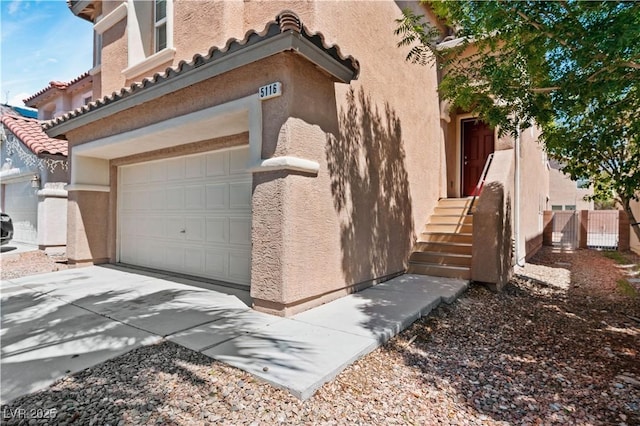 5116 Iron Crossing Ave, Las Vegas, NV 89131 - view of home's exterior featuring stucco siding, a tile roof, a garage, and driveway