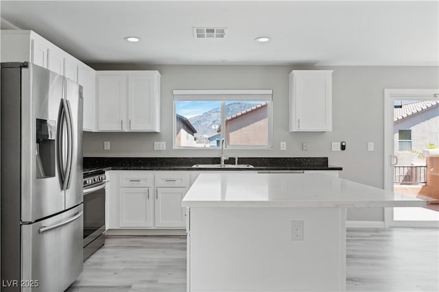 5116 Iron Crossing Ave, Las Vegas, NV 89131 - kitchen with stainless steel appliances, a sink, light wood-style floors, plenty of natural light, and recessed lighting